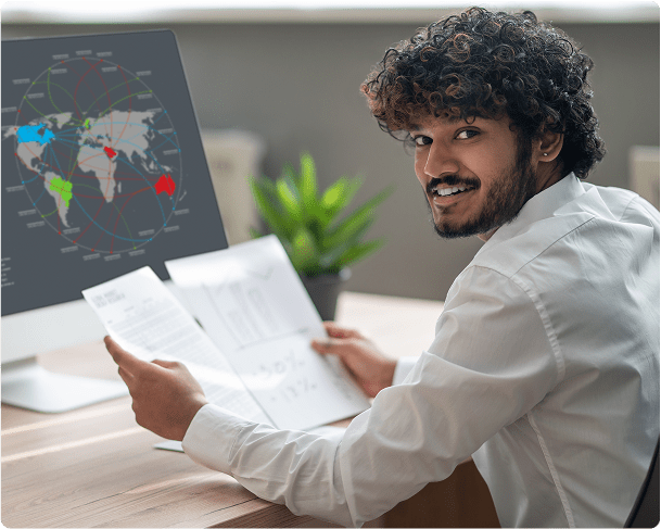 A young professional analyzing data and graphs for academic or business purposes in a modern office.