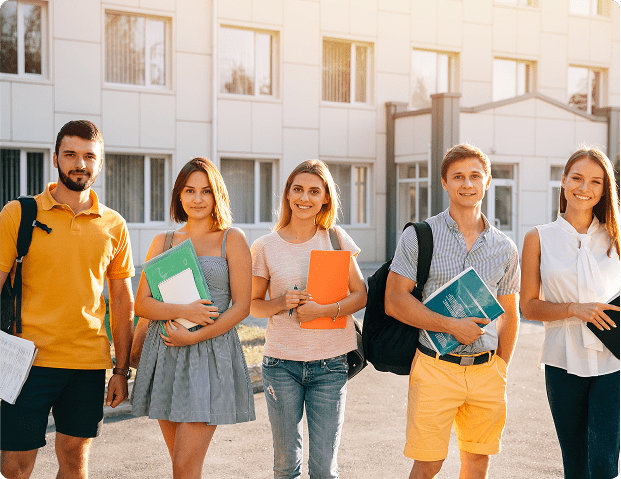 A group of diverse students posing together on campus with books, ready for their academic journey.